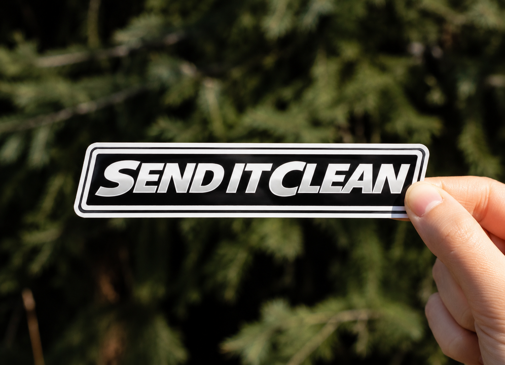 Send It Clean MTB sticker by CrankCaps held up outdoors 