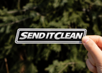 Send It Clean MTB sticker by CrankCaps held up outdoors 